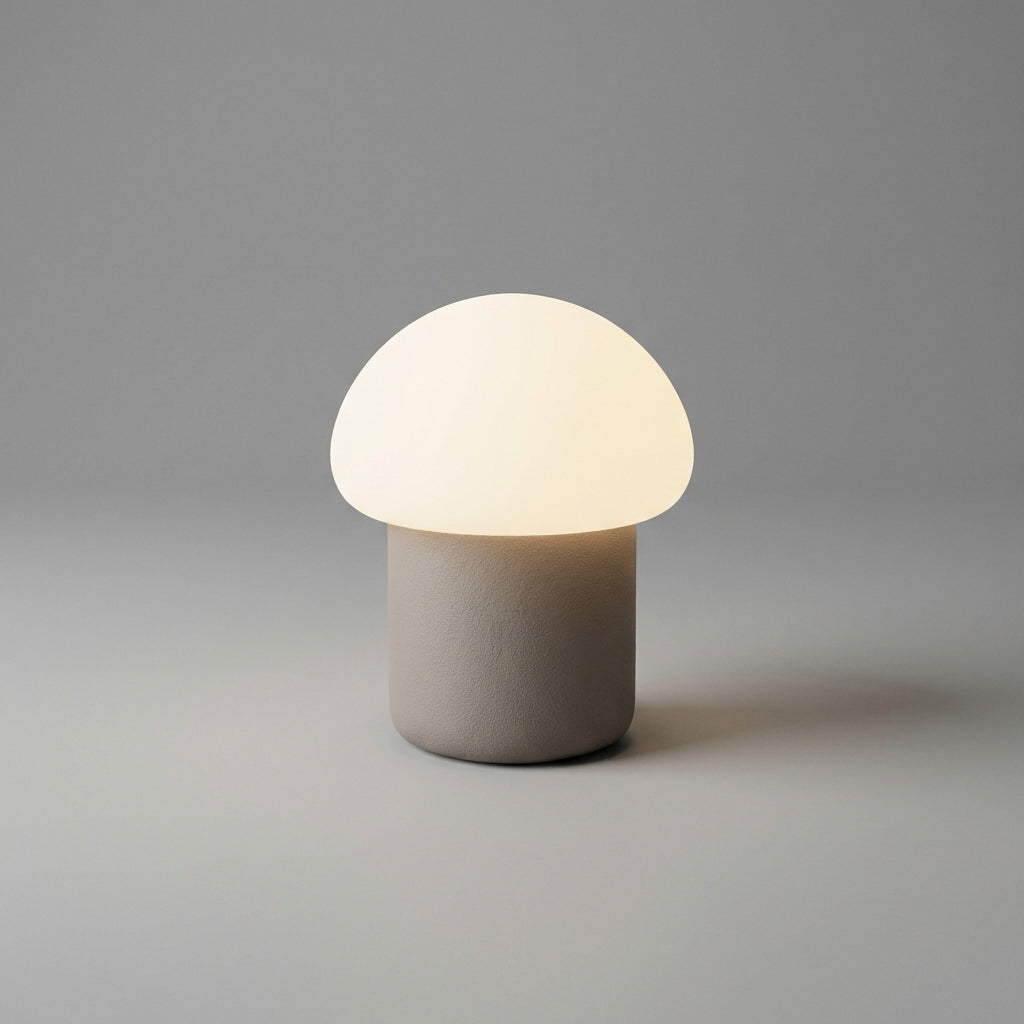 Minimalistyczna kompaktowa lampa stołowa z sylwetką grzyba i obciążoną podstawą