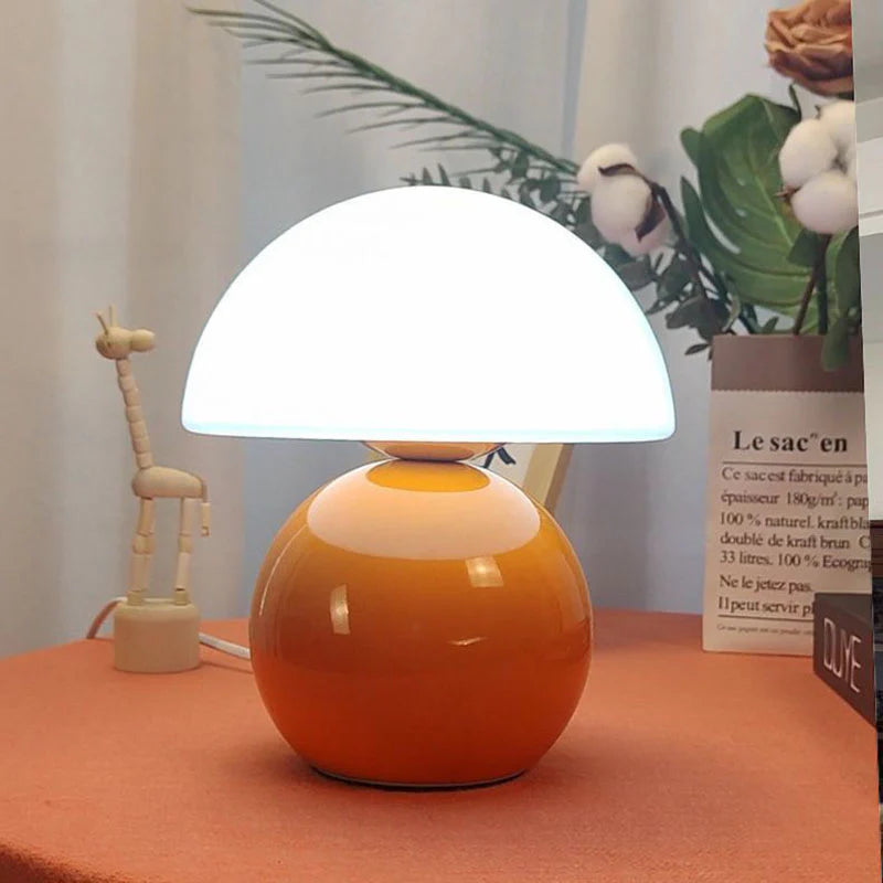 Kompaktowa stołowa lampa w stylu mid-century modern, z wygiętą kopułą i zaokrągloną podstawą