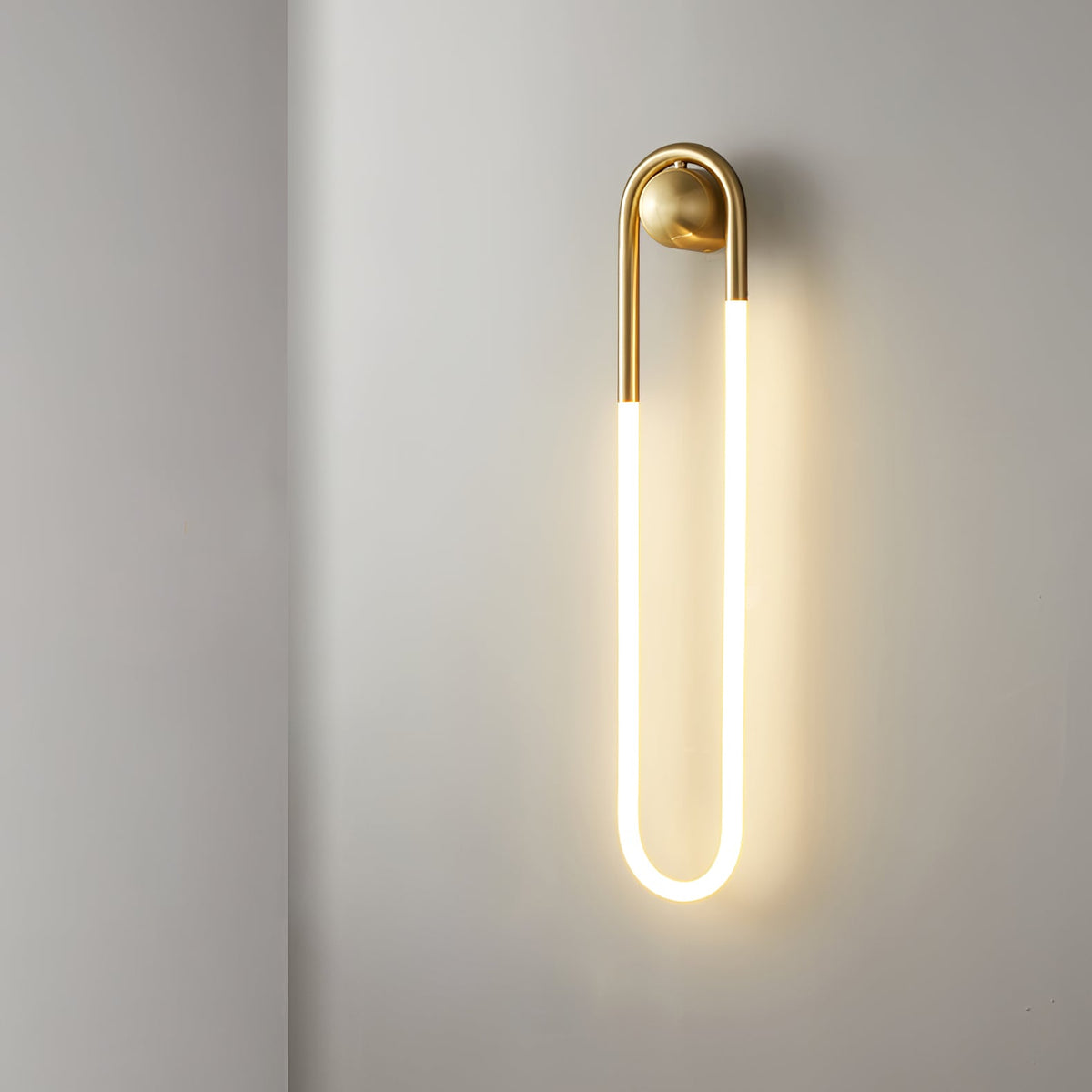 Minimalistyczna architektoniczna lampa ścienna z mosiężną ramą w kształcie pętli