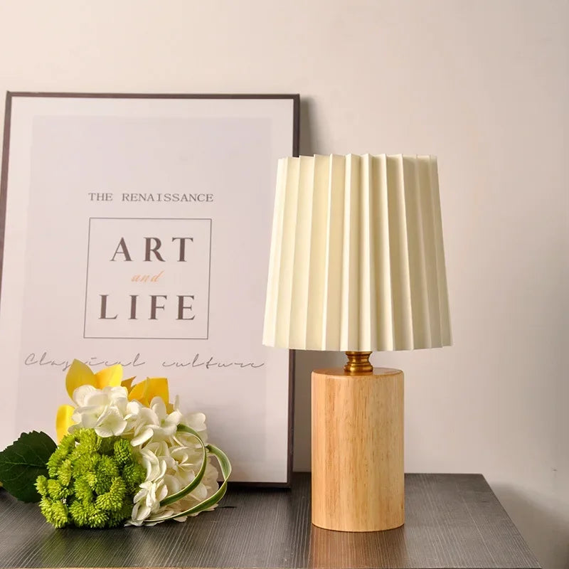 Lampa stołowa z plisowanym materiałowym kloszem i podstawą z litego drewna