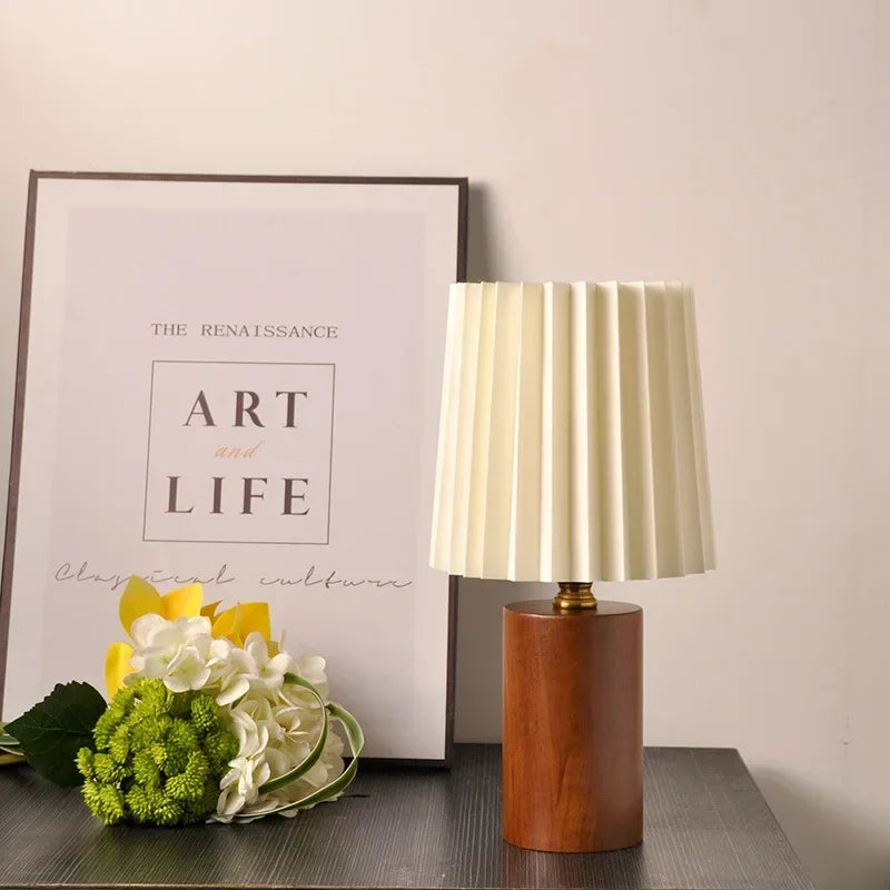 Lampa stołowa z plisowanym materiałowym kloszem i podstawą z litego drewna