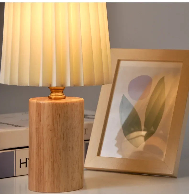 Lampa stołowa z plisowanym materiałowym kloszem i podstawą z litego drewna