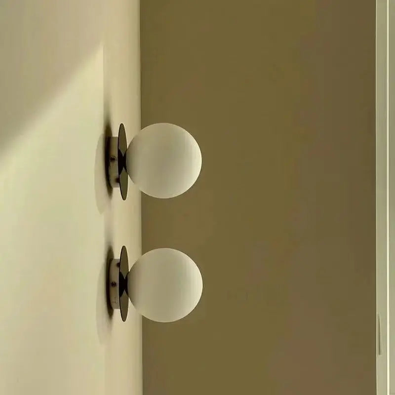 Nordycka lampa ścienna z opalowym szklanym kloszem w kształcie kuli i kutym żelazem