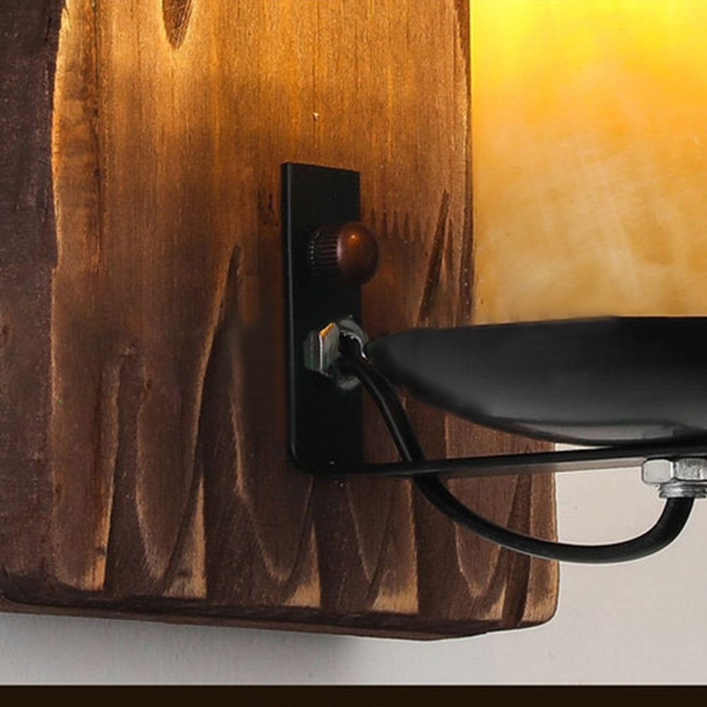 Rustykalna, ręcznie wykonana lampa ścienna z naturalnym usłojeniem drewna, przypominająca świecę