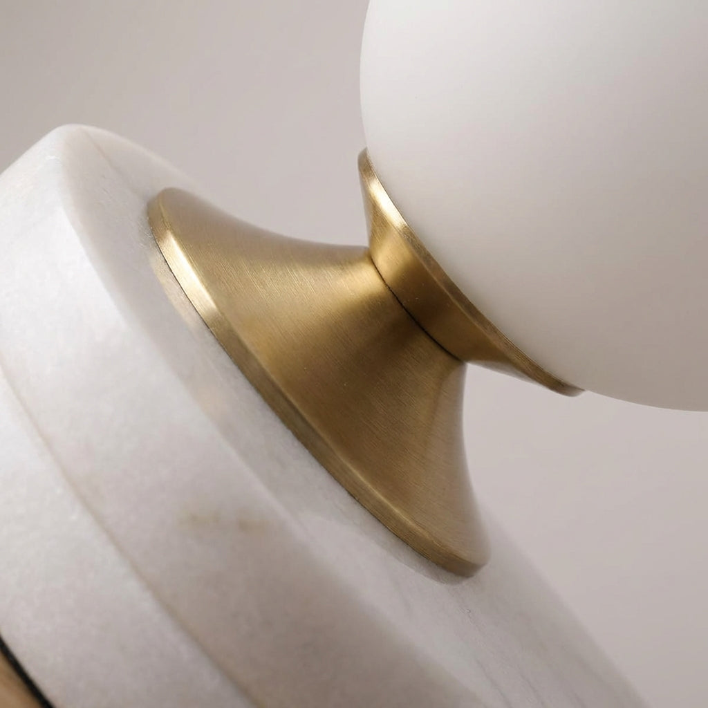Lampa stołowa z zaokrąglonym szklanym kloszem i zakrzywionym metalowym trzonem